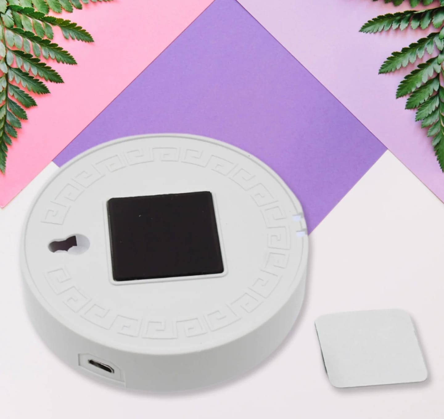 Round electronic device with screen on a colorful geometric background