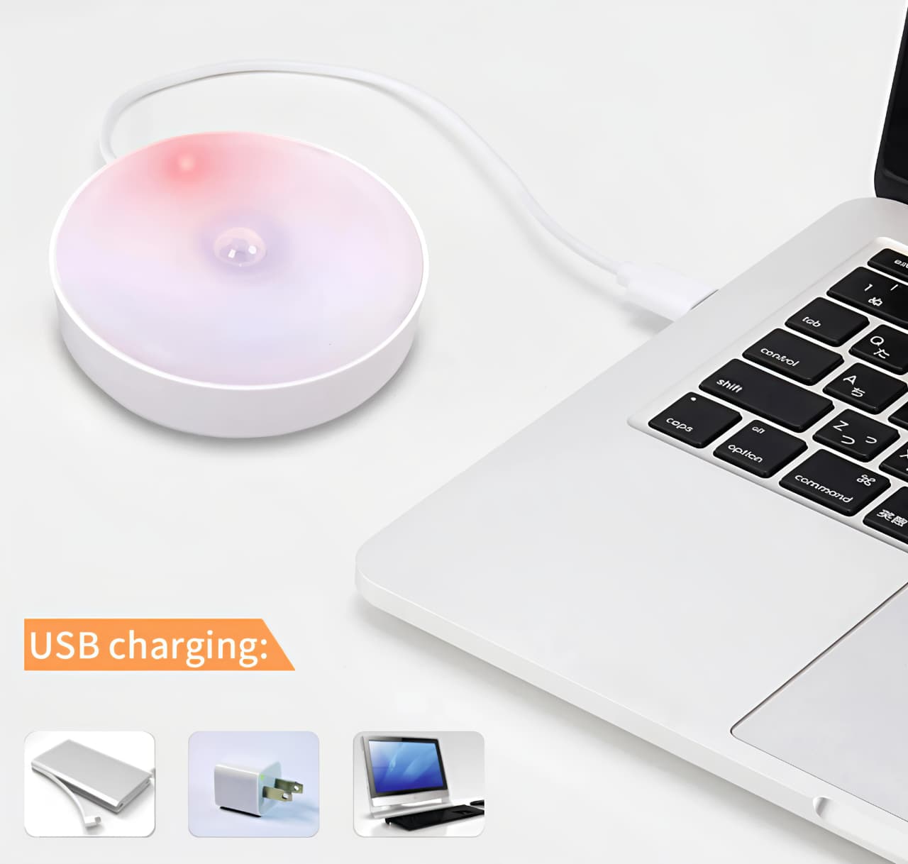 Laptop with a wireless charging pad and USB charging icons displayed.