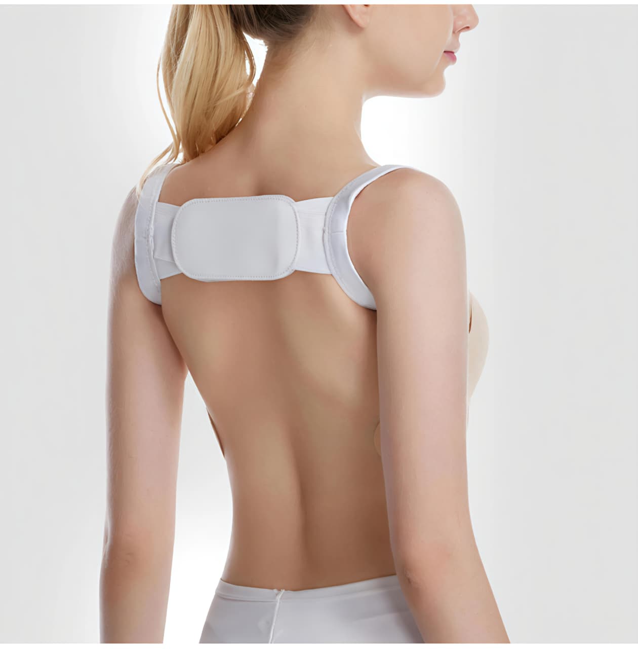 Woman wearing a white posture corrector on a plain background