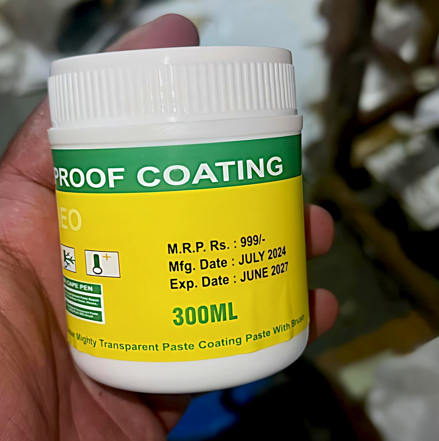Jar of proof coating with green and yellow label held by a hand